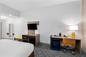a hotel room with a bed and a desk with a computer at Comfort Inn & Suites Fort Smith I-540 in Fort Smith