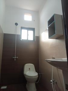 ein Badezimmer mit Toilette und Waschbecken und einem Fenster in der Unterkunft Family Guest House in Lahore