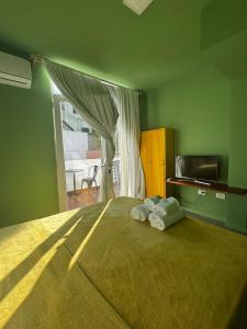 a green bedroom with a large bed with a window at Hostel 555 in La Plata