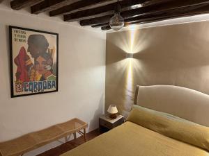 a bedroom with a bed and a poster on the wall at Casa Entre Lunas - Stylish Rustic Retreat in Olvera