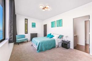 a bedroom with a blue bed and a blue chair at Waterfront Haven with Spectacular View in Bainbridge in Rollingbay