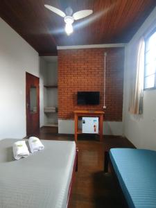Una habitación con dos camas y un televisor de pantalla plana. en Hospedagem Prática 3 hóspedes, en São Lourenço