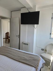 a bedroom with a bed and a tv on the wall at Alma Jujeña in San Salvador de Jujuy