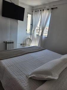 a bedroom with a large white bed with a window at Alma Jujeña in San Salvador de Jujuy