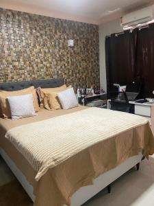 a bedroom with a large bed in front of a brick wall at Casa Cop 30 in Belém