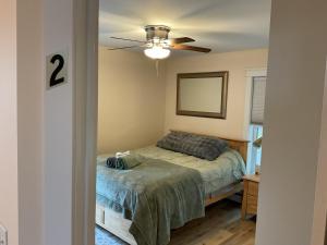 ein Schlafzimmer mit einem Bett und einem Deckenventilator in der Unterkunft Roberts Lake House Room 2 & Room 3 & Upstairs in Colchester