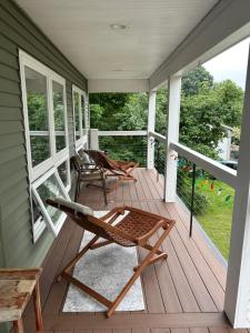 eine abgeschirmte Veranda mit einer Bank und Stühlen darauf in der Unterkunft Roberts Lake House Room 2 & Room 3 & Upstairs in Colchester + 10 Fotos