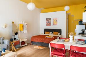a room with a bed and a table with red chairs at Dotan's Boutique Studios - By The Beach! in Tel Aviv