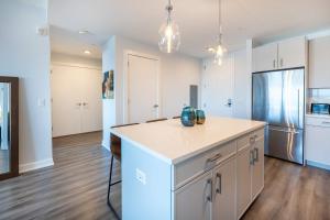 a kitchen with white cabinets and a refrigerator at Luxury Apartment in Stamford - Gym & Pool Access in Stamford +9 photos