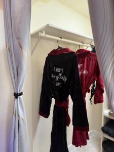 凤凰城Adult-only guesthouse with HOT TUB and KING BED的衣柜里有一件黑色衬衫和红色衣服。