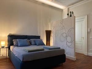a bedroom with a large bed with blue pillows at Partifour in Bergamo