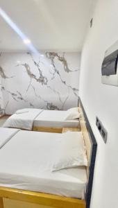 two bunk beds in a room with a wall at Heyleez Guest House in Himmafushi