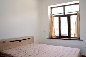 a bedroom with a bed and a window at Red House in Chok-Tal
