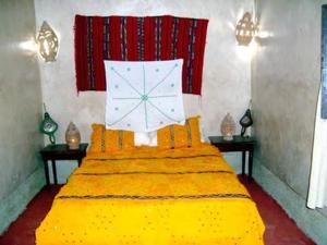 a bedroom with a large bed with a clock on it at Dar dmana chez l'habitant in Skoura