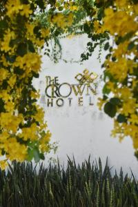 a sign for the crown hotel with yellow flowers at The New Crown Hotel in Dambulla