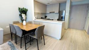a kitchen and dining room with a wooden table and chairs at Central 2br Apt Yas F1 Circuit in Abu Dhabi