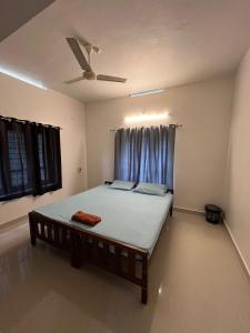 Un dormitorio con una cama con ventilador de techo. en villa mud apples, en Varkala