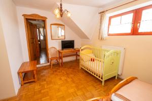 Una habitación con una cuna y un escritorio con televisión. en Winery Toplak, en Juršinci