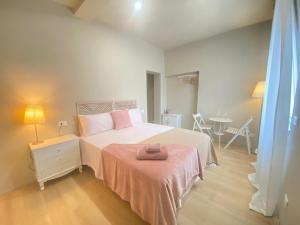 a bedroom with a bed with a pink blanket and a table at Dreamhouse B&B in Pioltello