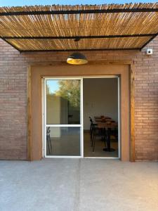 una puerta corredera de cristal que da a un patio con mesa en Colibrí - Smart Hostel, en San Juan 25 fotos más