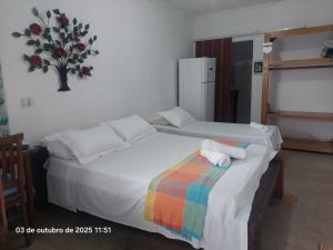- une chambre avec 2 lits et une couverture arc-en-ciel dans l'établissement Pousada e Hostel La Civetta - Maresias, à São Sebastião