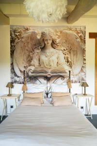 a bed with a statue of a woman reading a book at La bastide de Meilhouret in Larroque