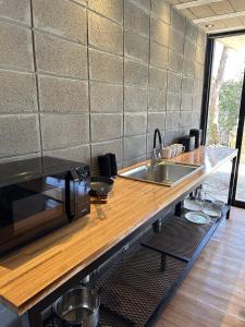 a kitchen counter with a sink and a microwave at Pedre Loft in La Pedrera