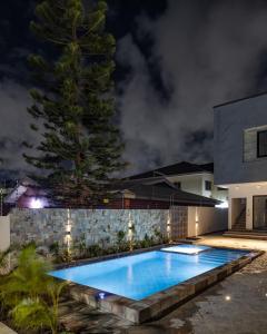 a swimming pool in the backyard of a house at night at Grey Assets - Apartment 2 in Spintex