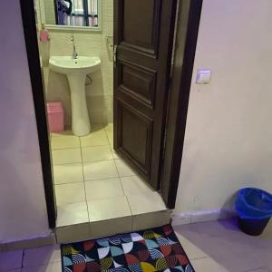 a bathroom with a toilet and a sink and a door at Chambre liberté 6 Dakar in Dakar