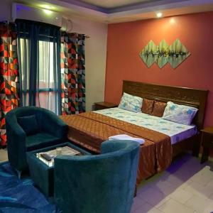 a bedroom with a bed and a chair in a room at Chambre liberté 6 Dakar in Dakar