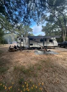un homme debout devant un camping-car dans un champ dans l'établissement RVParks 365, à Seven Points