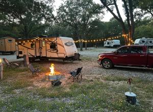 un camping avec une tente, une voiture et un feu dans l'établissement RVParks 365, à Seven Points