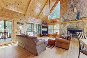 ein Wohnzimmer mit 2 Sofas und einem Steinkamin in der Unterkunft River Escape On The Toccoa in Blue Ridge