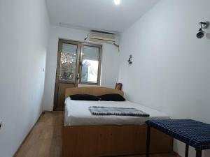 a small bedroom with a bed and a window at Mlin Balkan Rooms in Skopje +3 photos