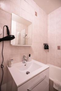 a bathroom with a sink and a mirror and a tub at Appart Centre-ville, Cathédrale, Petite France in Strasbourg