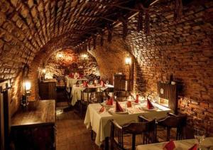 a restaurant with tables and chairs and a brick wall at ALBERT RESIDENCE Brasov in Braşov