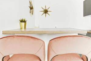 two pink chairs sitting in front of a desk at Convinient souplex basement 5mn near métro and Montmartre in Paris