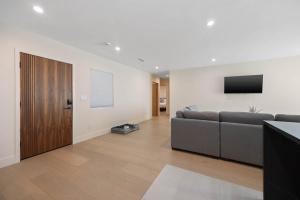 a living room with a couch and a flat screen tv at New Listing Valley Villa by Colby & Conrad in Winnetka +30 photos