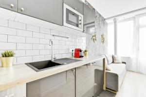 a kitchen with a sink and a couch at Convinient souplex basement 5mn near métro and Montmartre in Paris