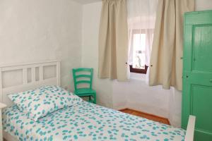 1 dormitorio con 1 cama y 2 sillas verdes en Holiday home Castelier en Vodnjan