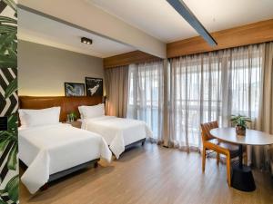 a hotel room with two beds and a table at Grand Mercure SP Itaim Bibi in Sao Paulo +158 photos
