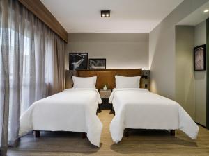 two beds in a hotel room with white sheets at Grand Mercure SP Itaim Bibi in Sao Paulo +168 photos