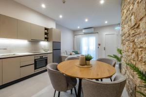 a kitchen and dining room with a table and chairs at LV Apartments Ioannina in Anatolí