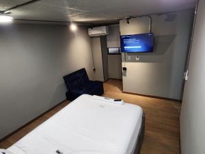 a room with a bed and a chair and a screen at Eureka Living in Bucaramanga