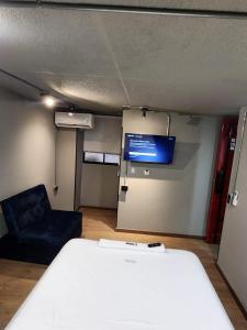 a room with a bed and a couch and a tv at Eureka Living in Bucaramanga +5 photos