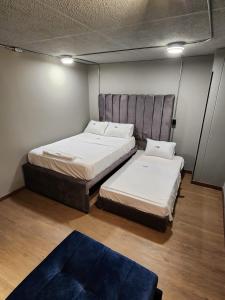 a room with two beds and a rug at Eureka Living in Bucaramanga +4 photos