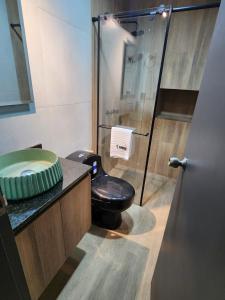 a bathroom with a toilet and a glass shower at Eureka Living in Bucaramanga