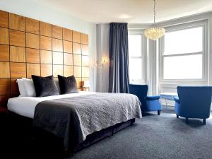 フォークストンにあるThe View Hotel Folkestone, a member of Radisson Individualsのベッドルーム(大型ベッド1台、青い椅子付)