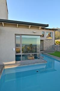 una piscina frente a una casa en At Last Glentana Apartment, en Groot Brak Rivier