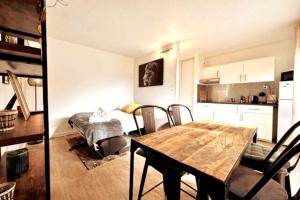 a kitchen and a dining room with a table and a bedroom at Lion - Centre-ville - MA CONCIERGERIE in Vesoul
